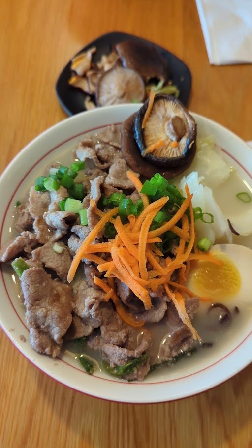 Steaming ramen bowls on a casual table.